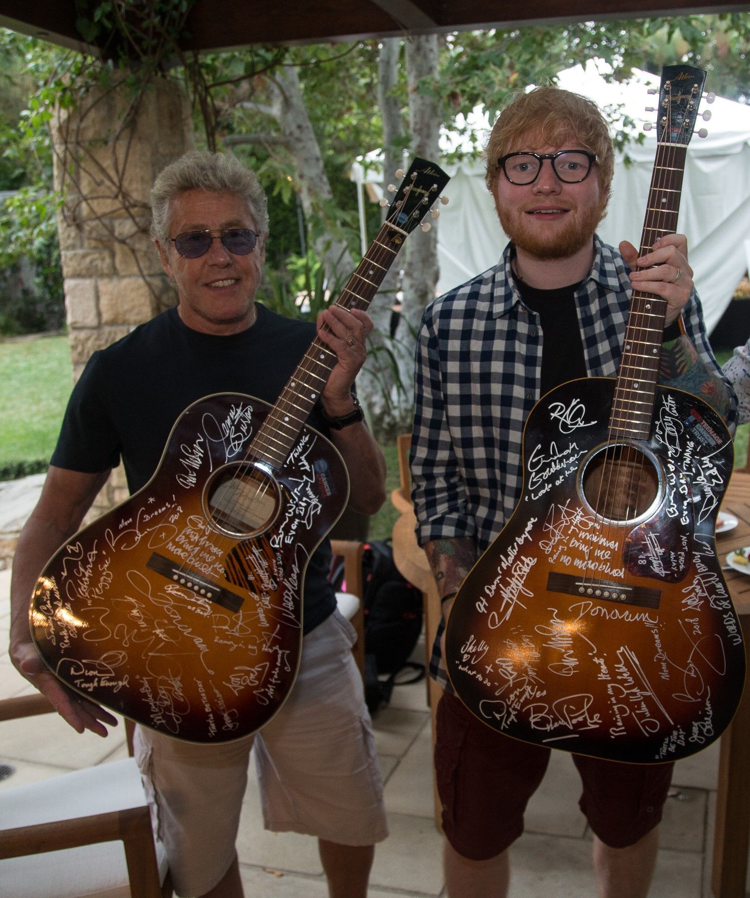 Roger Daltrey and Ed Sheeran holding signed Buddy Holly guitars